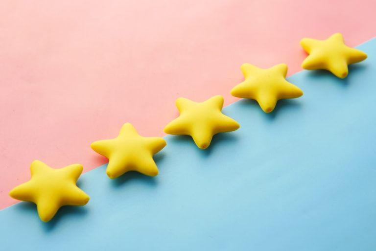 A row of rating stars on a coloured surface